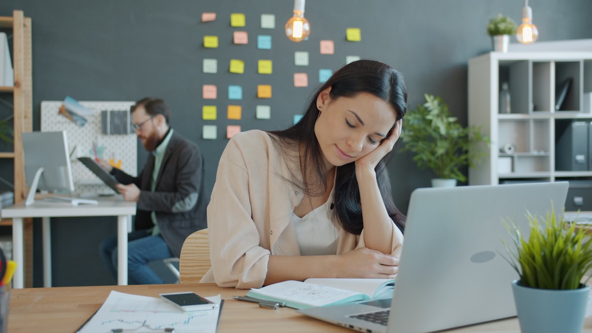 Un'analista stanca alla scrivania: la coda degli alert non finisce mai.